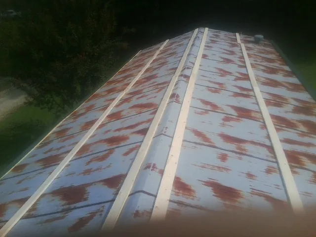 Rusted metal roof panels with new wood purlins before replacement — Storm Damage Roof Repair in Schiller Park by Roofing Brothers