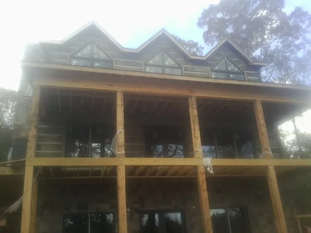 Dormers and porch framing on a large log home under construction — Roof Coating work by our crew in Schiller Park