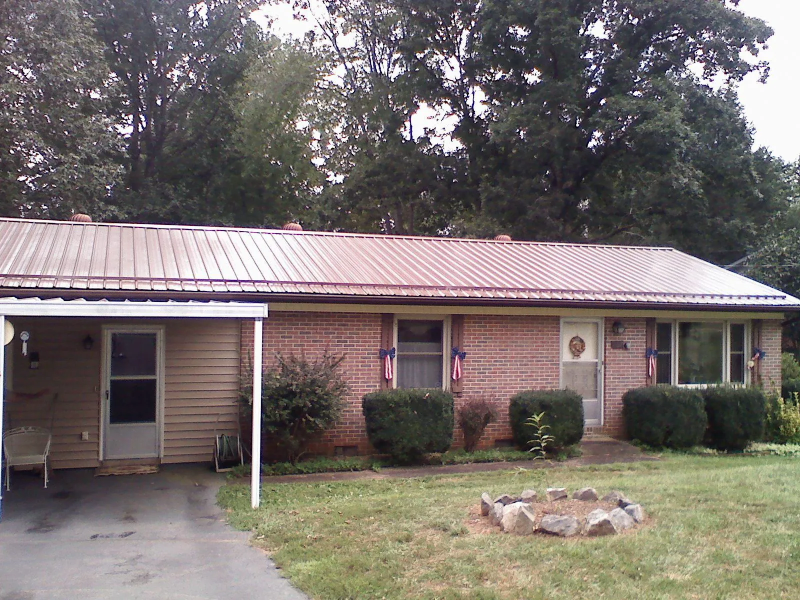 Bronze metal roof and carport on a brick ranch home — Roof Repair work by our crew in Schiller Park